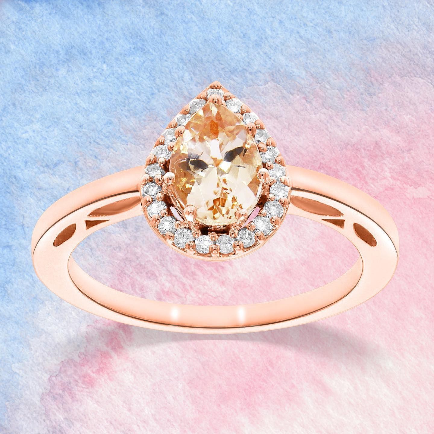 Roségouden ring met een peervormige, perzikkleurige edelsteen, omringd door diamanten.