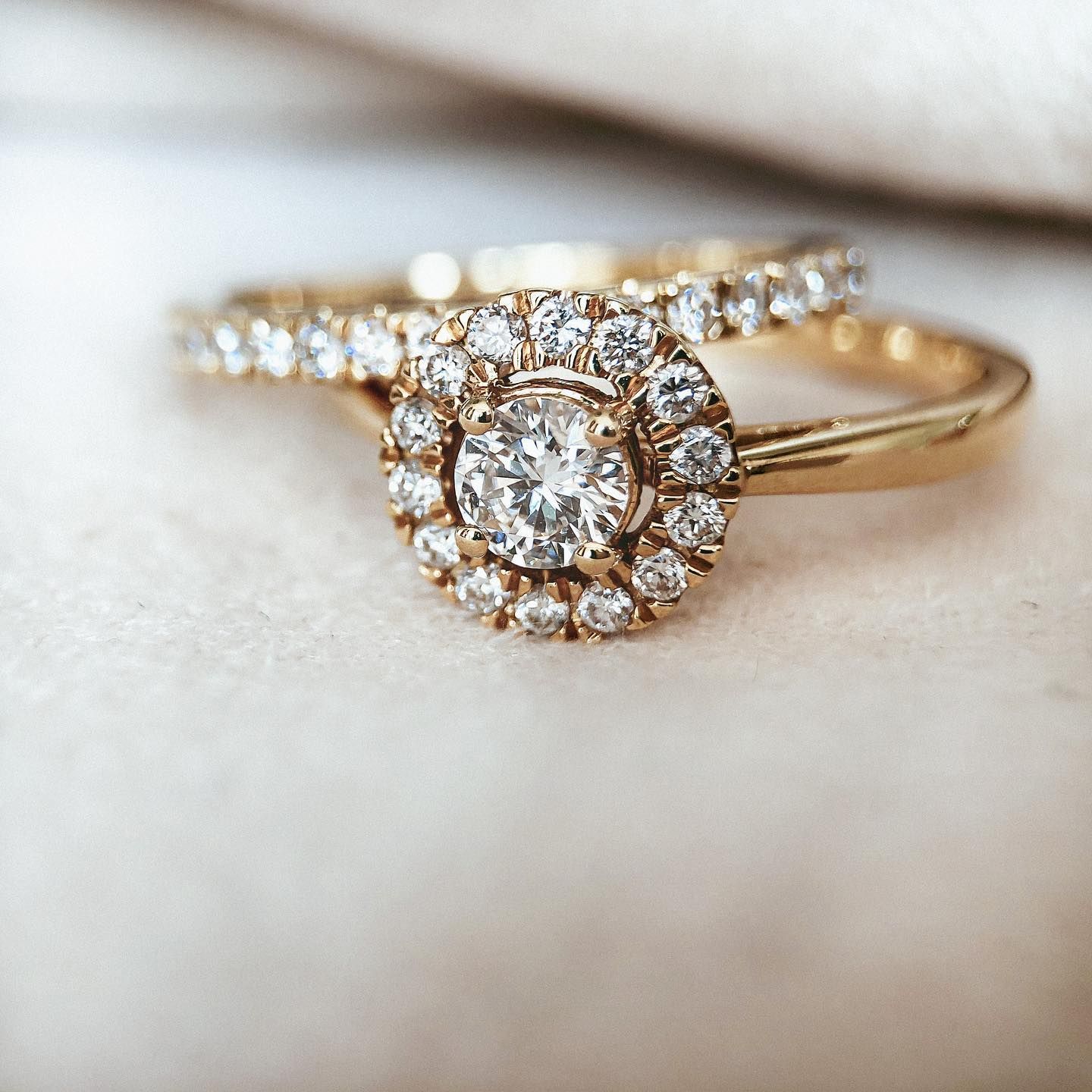 Gouden verlovingsring met een bijpassende diamanten band op een wit oppervlak.