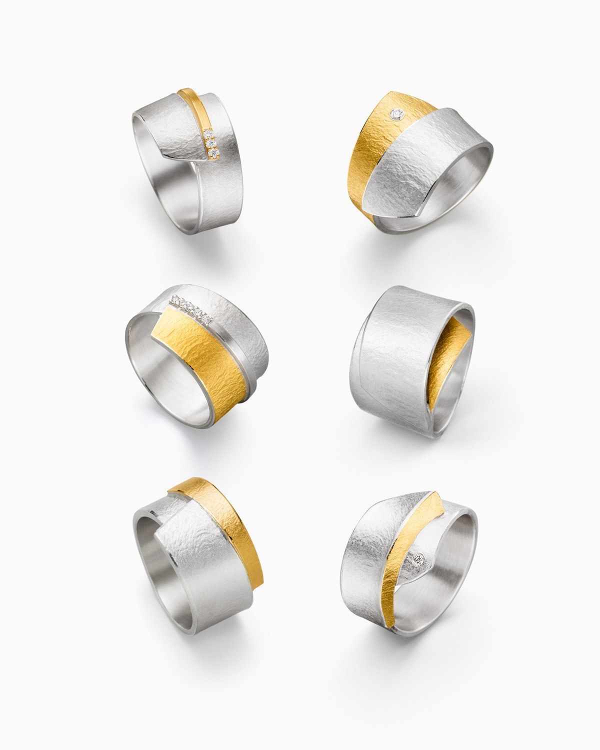 Zes zilveren ringen met gouden banden.