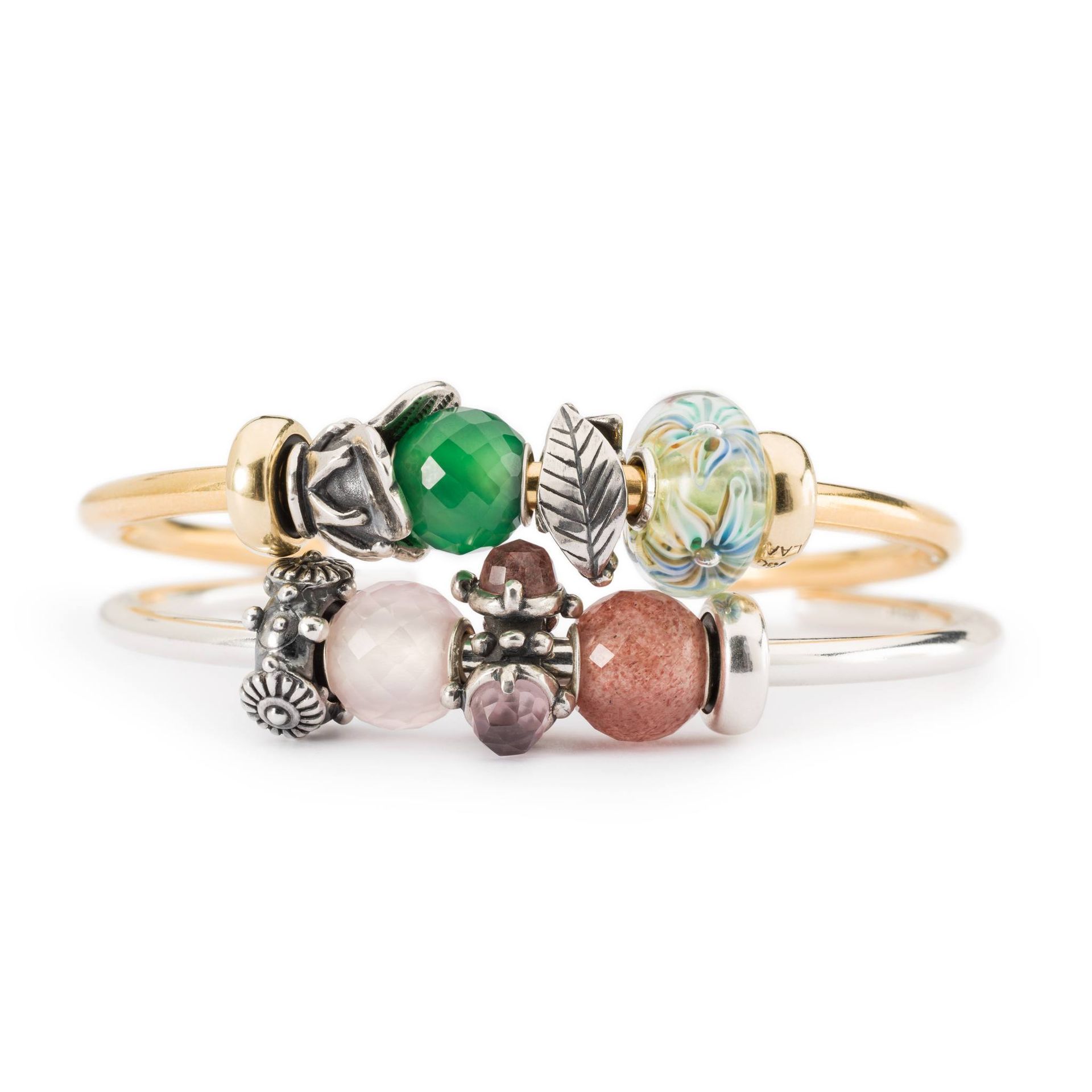 Twee ringen: goud en zilver, beide versierd met verschillende kleurrijke kralen en bedels.