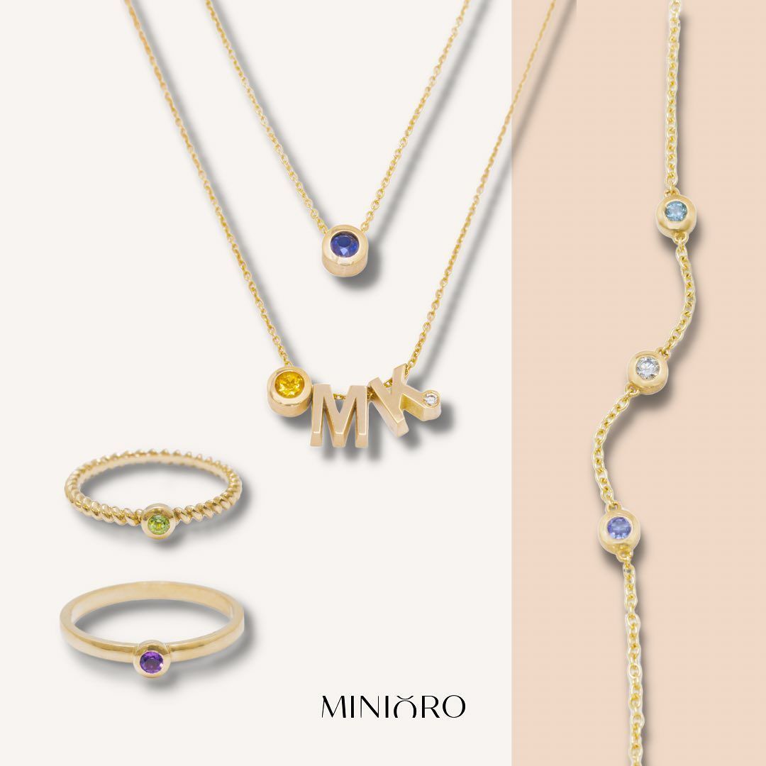 Gouden sieradenset: kettingen, ringen en een armband met gekleurde edelstenen.