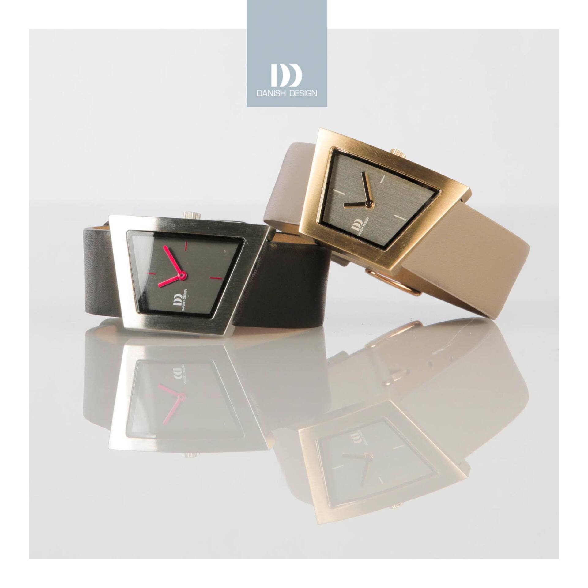 Twee geometrische horloges, één van zilver en één van goud, rusten op een reflecterend oppervlak.