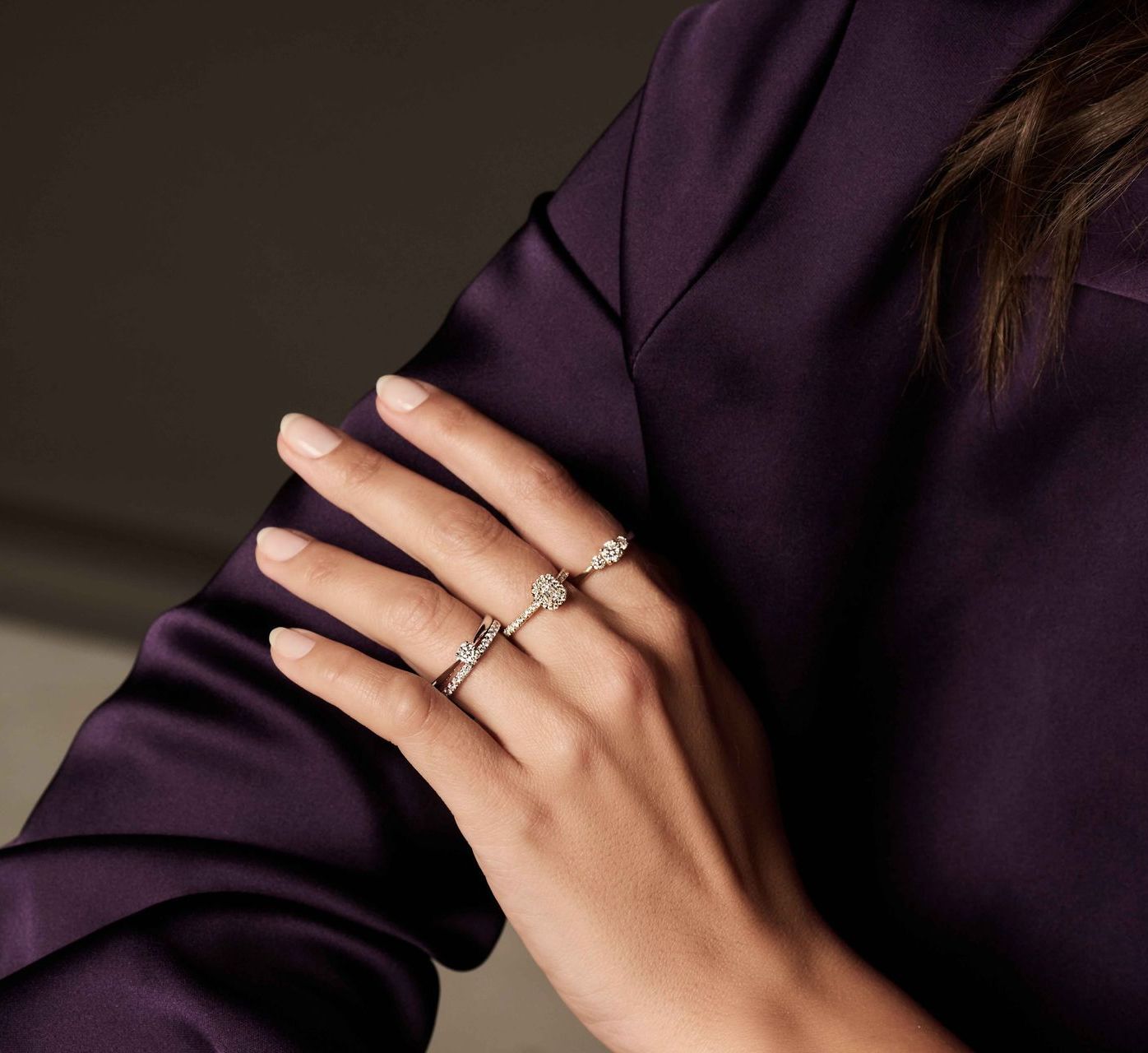 Hand met drie ringen, rustend op paarse stof.
