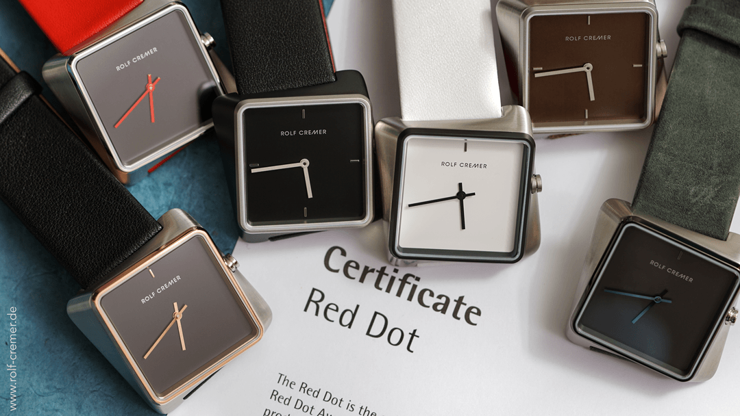 Horloges met vierkante wijzerplaten in verschillende kleuren en zwarte bandjes, rond een 