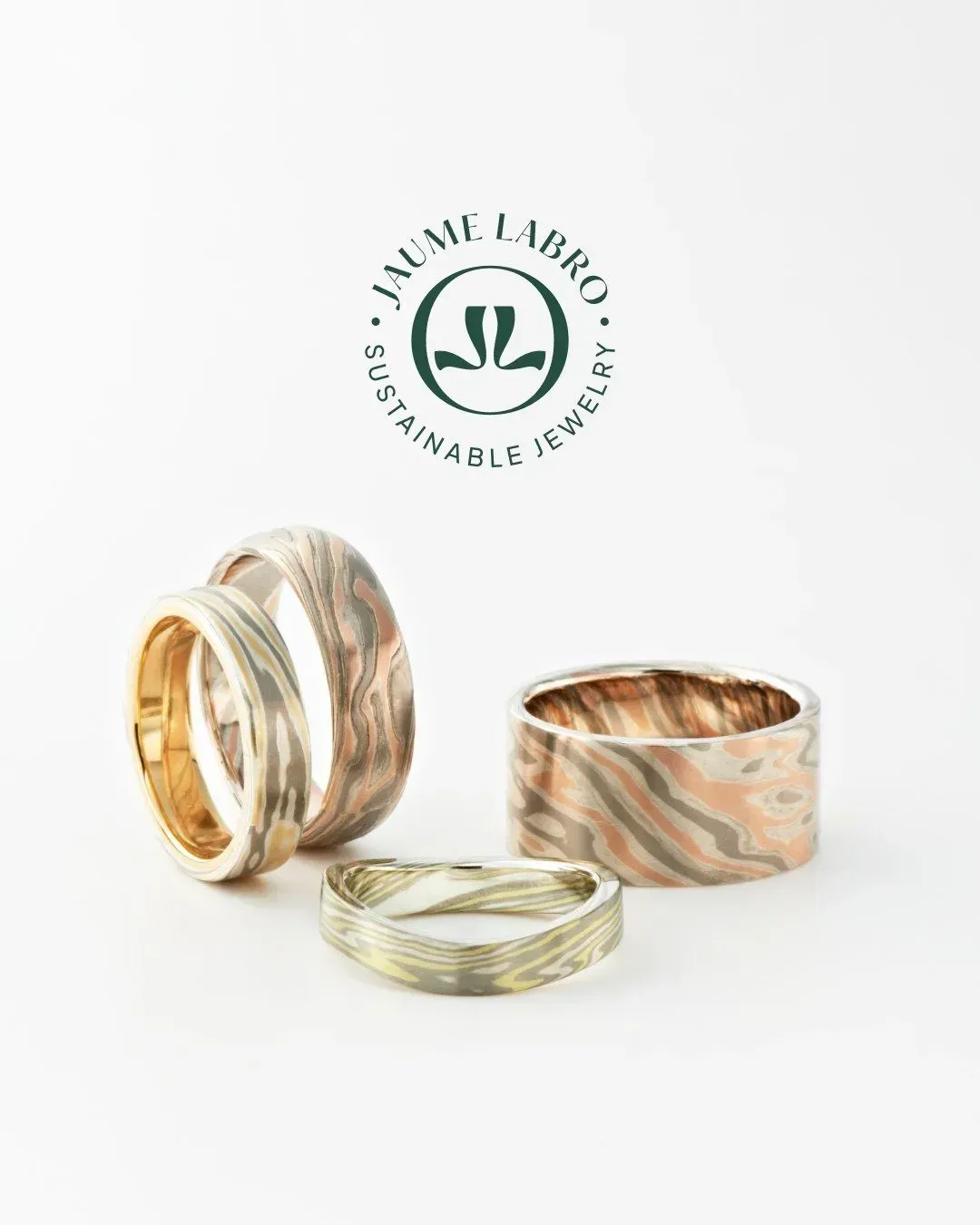 Vier ringen van gepatroneerd metaal, met het logo 