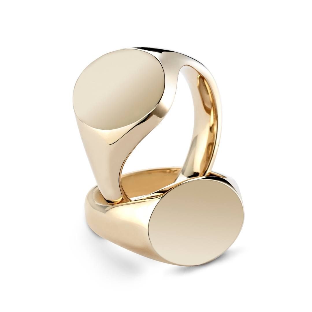 Twee gouden zegelringen, de ene rechtopstaand op de andere, beide met ronde, lege zijden.