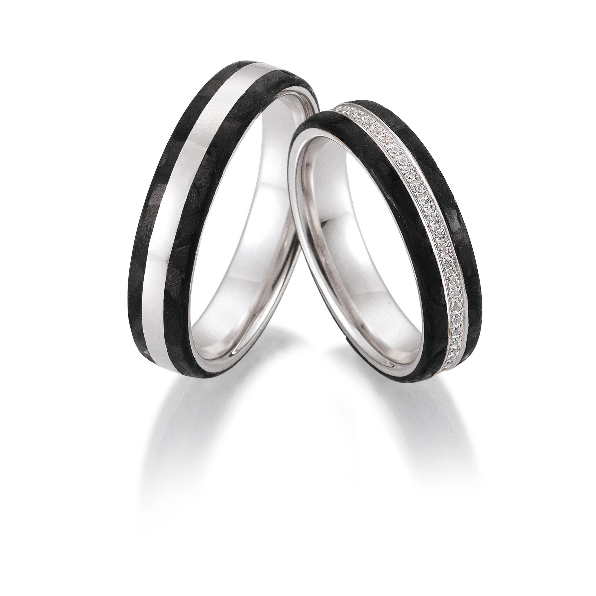 Twee zilveren trouwringen met zwarte inleg; één met een zilveren band, de ander met een diamanten band.