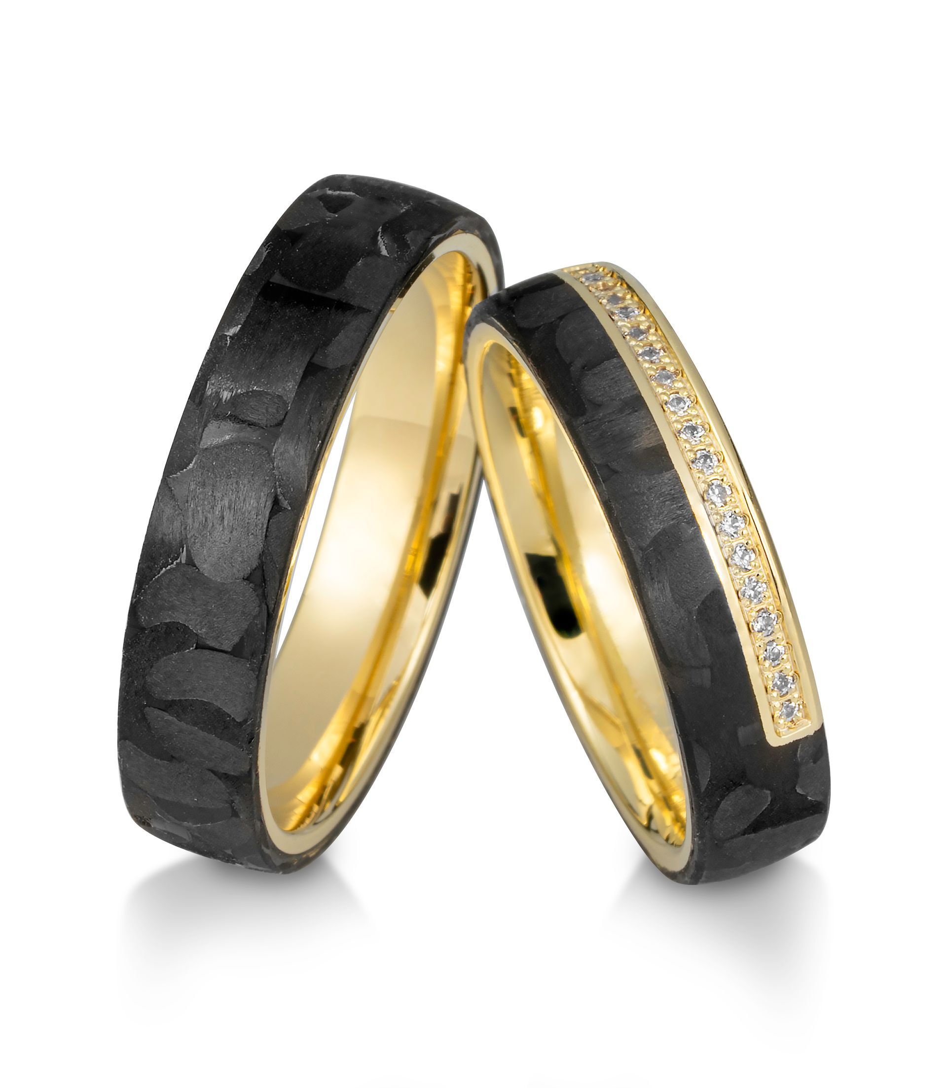 Twee trouwringen: zwarte buitenkant, gouden binnenkant, één met diamanten.