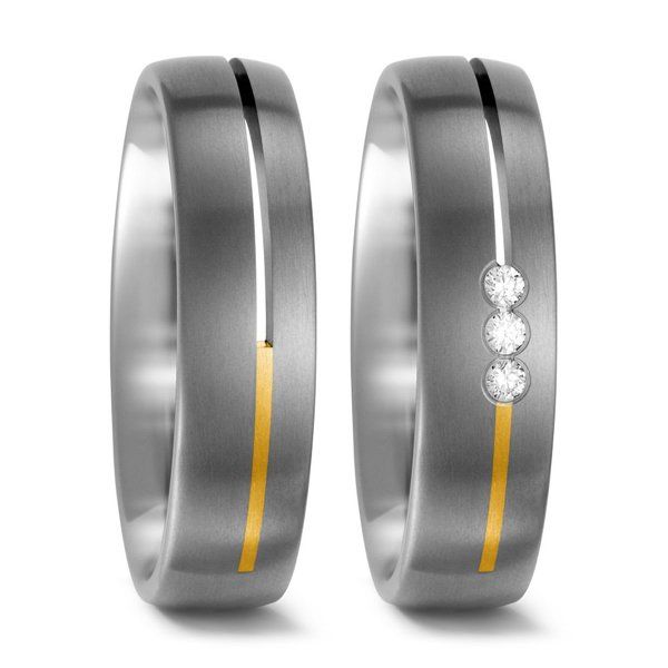 Twee zilveren trouwringen met gouden inleg. Eén met drie diamanten.