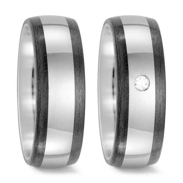 Twee zilveren trouwringen met een donkere band en een diamant.