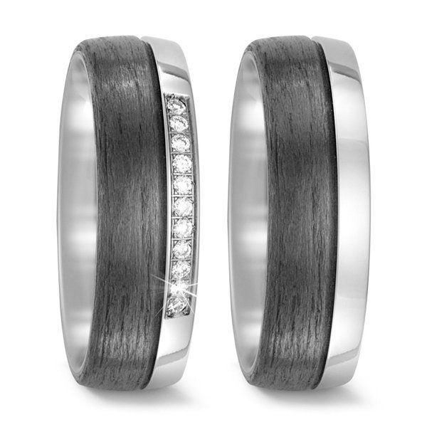 Twee trouwringen met een donker houtnerf in het midden en een zilveren rand, waarvan één met ingelegde diamanten.
