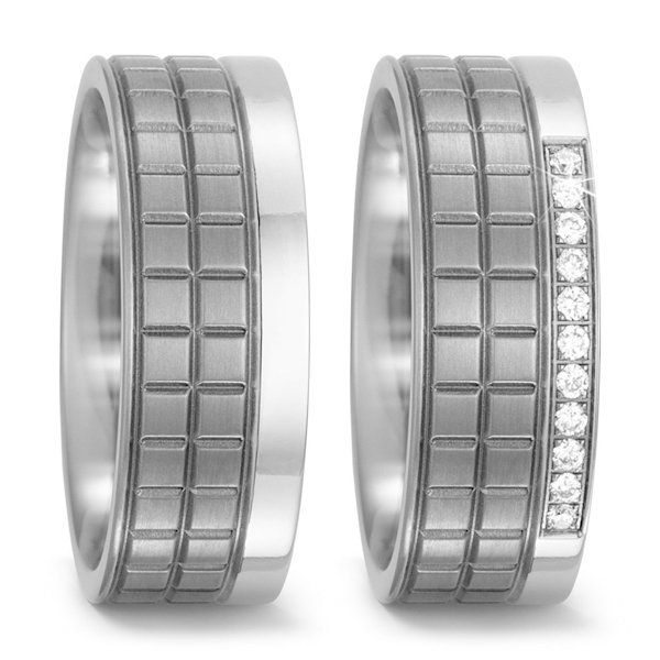 Twee zilveren trouwringen, waarvan één met een rij diamanten. Beide met een ruitmotief.