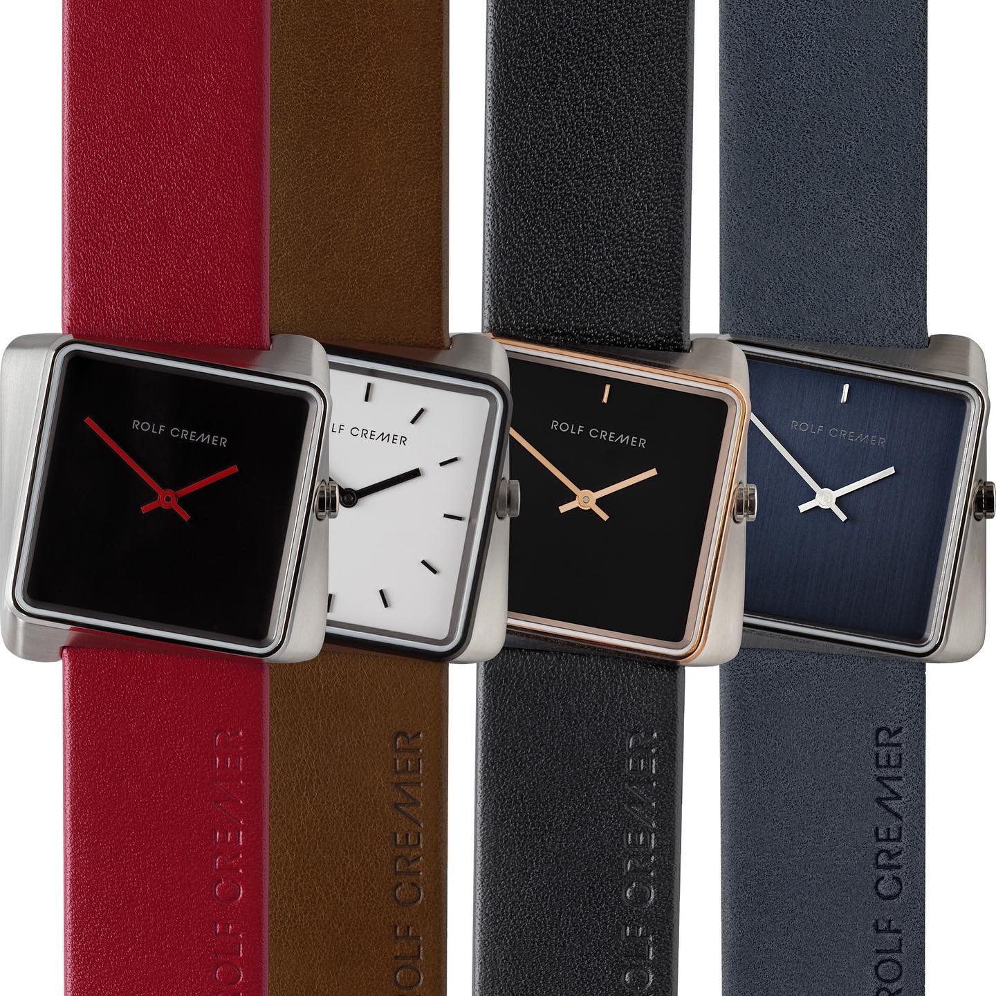 Vier horloges met vierkante wijzerplaten en leren banden in de kleuren zwart, wit, rood en blauw.