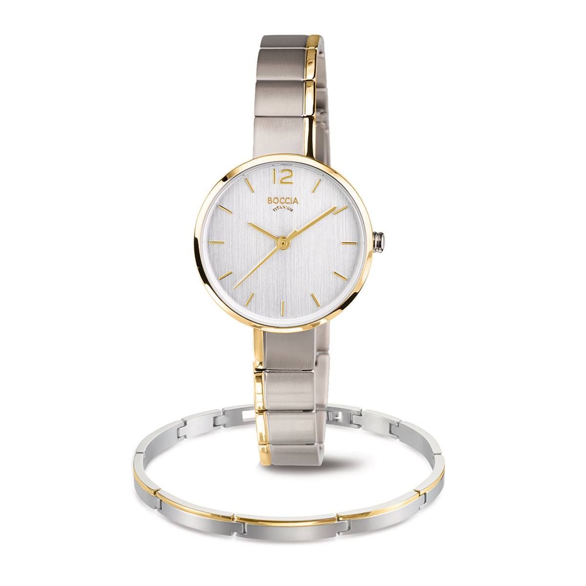 Zilveren en gouden polshorloge en armband op een witte achtergrond.