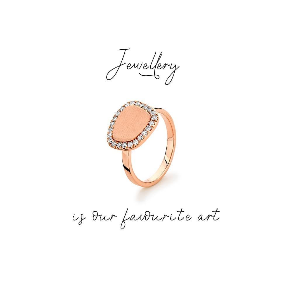 Roségouden ring met een perzikkleurige steen en een halo van diamanten. De tekst luidt: