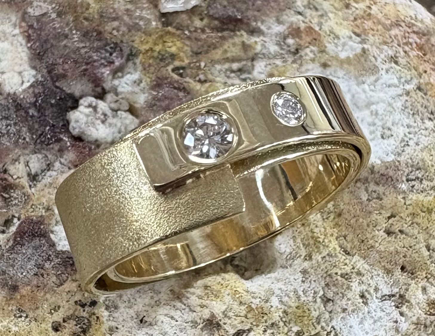 Gouden sieraden: ringen op een houten blok, ketting met gewikkelde gouden kralen.