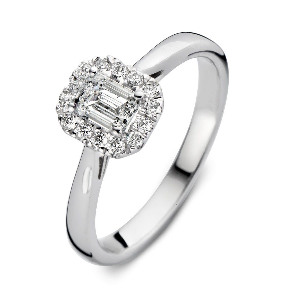 Diamanten ring met een smaragd geslepen middelste steen, omgeven door een halo van kleinere diamanten, op een witgouden band.