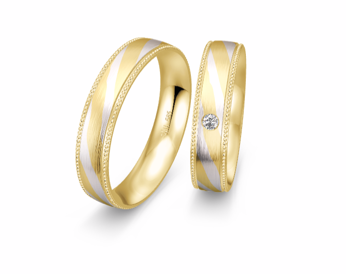 Gouden vlinderring met getextureerde vleugels en kleine diamanten, op een bruin oppervlak.