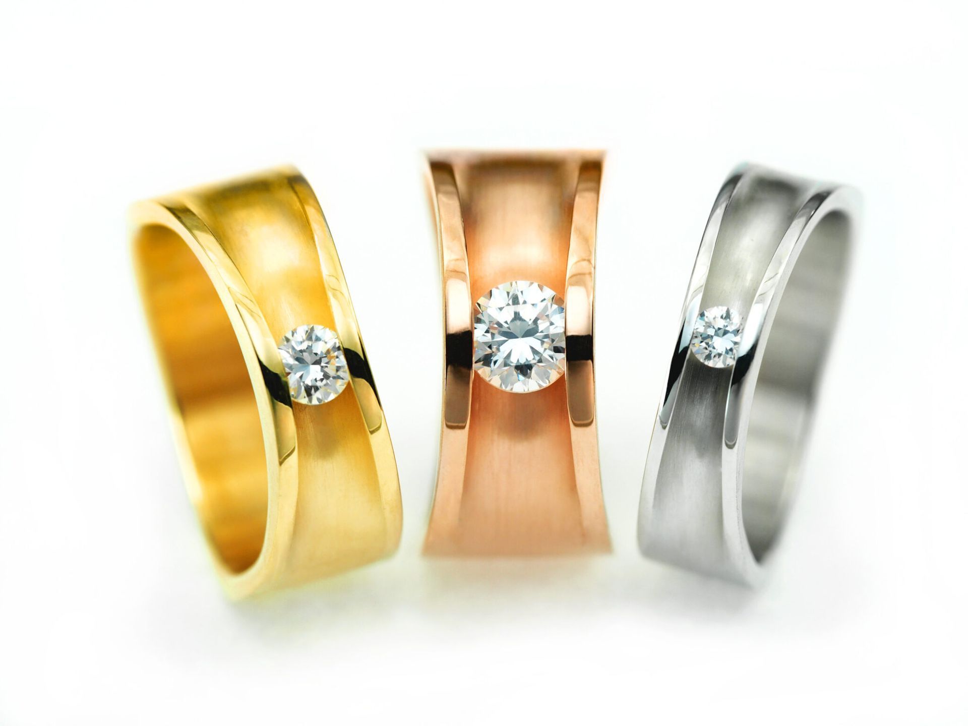 Een man draagt ​​een vrouw op een onverharde weg in een bos. Zij glimlacht, hij kijkt de toeschouwer aan.