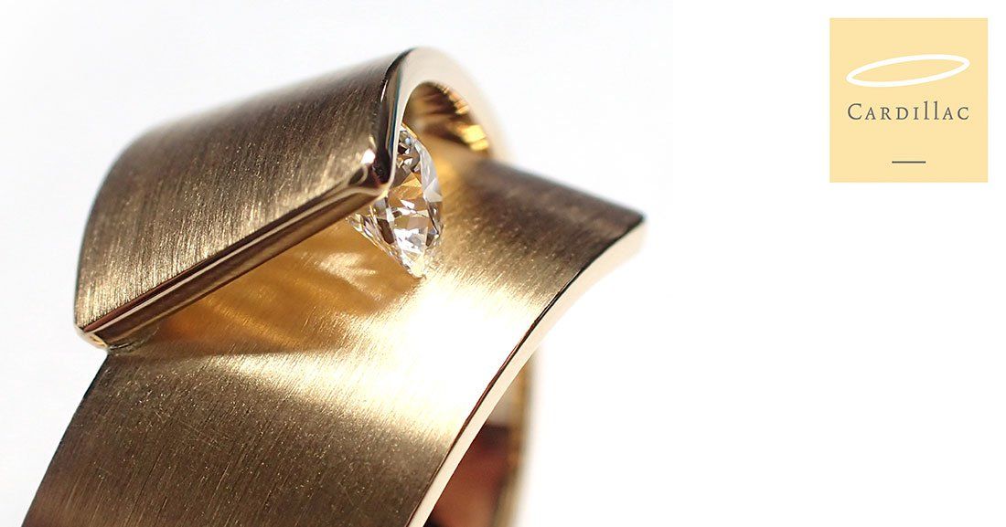 Gouden ring met een kleine diamant en gebogen ontwerp.