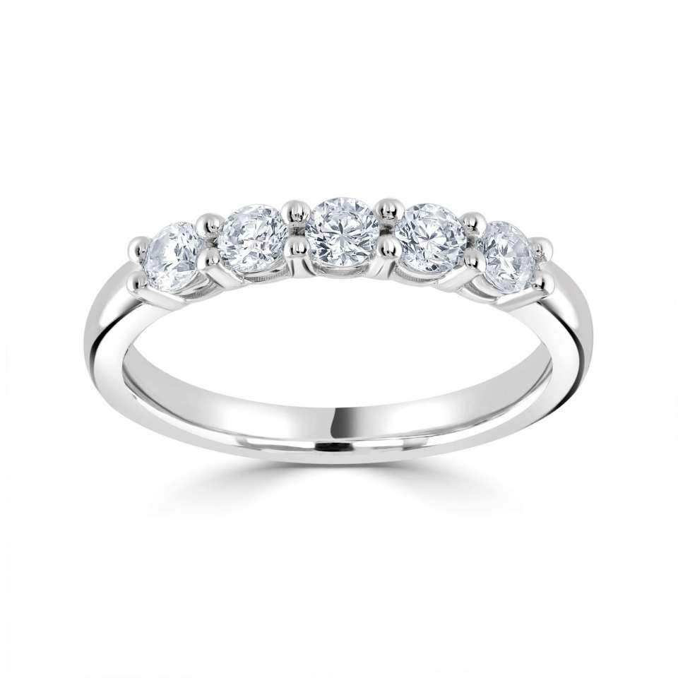 Ring met vijf diamanten op een witgouden band, gezet op een witte achtergrond.