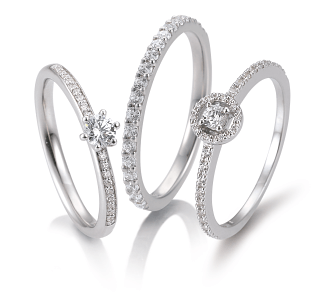 Gouden ring met een rij heldere, markiesvormige edelstenen, afgezet tegen een reflecterend blauw oppervlak.