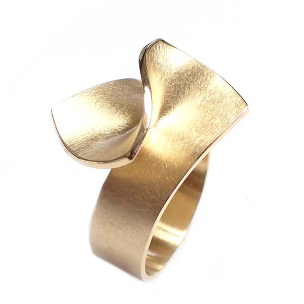 Hand met een zilveren ring met turquoise inleg, close-up tegen een onscherpe achtergrond.