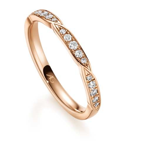 Roségouden trouwring met diamanten en een gedraaid ontwerp.