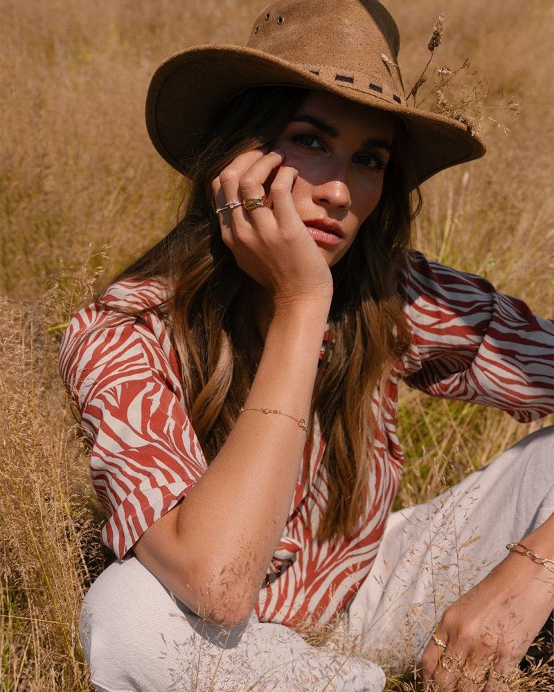 Bruid in een versierde trouwjurk, met witte schoenen versierd met kristallen.