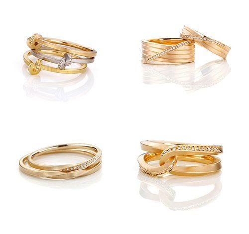 Vier gouden ringen, elk met een uniek ontwerp, gerangschikt op een witte achtergrond. Sommige zijn bezet met diamanten.