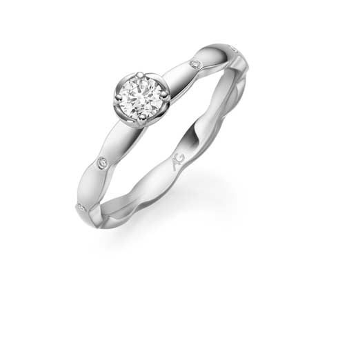 Verlovingsring van witgoud met een ronde diamant in het midden en kleine accentdiamanten.