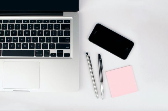 MacBook and iPhone with pens and sticky note – bookkeeping services and VAT support for small businesses in Surrey