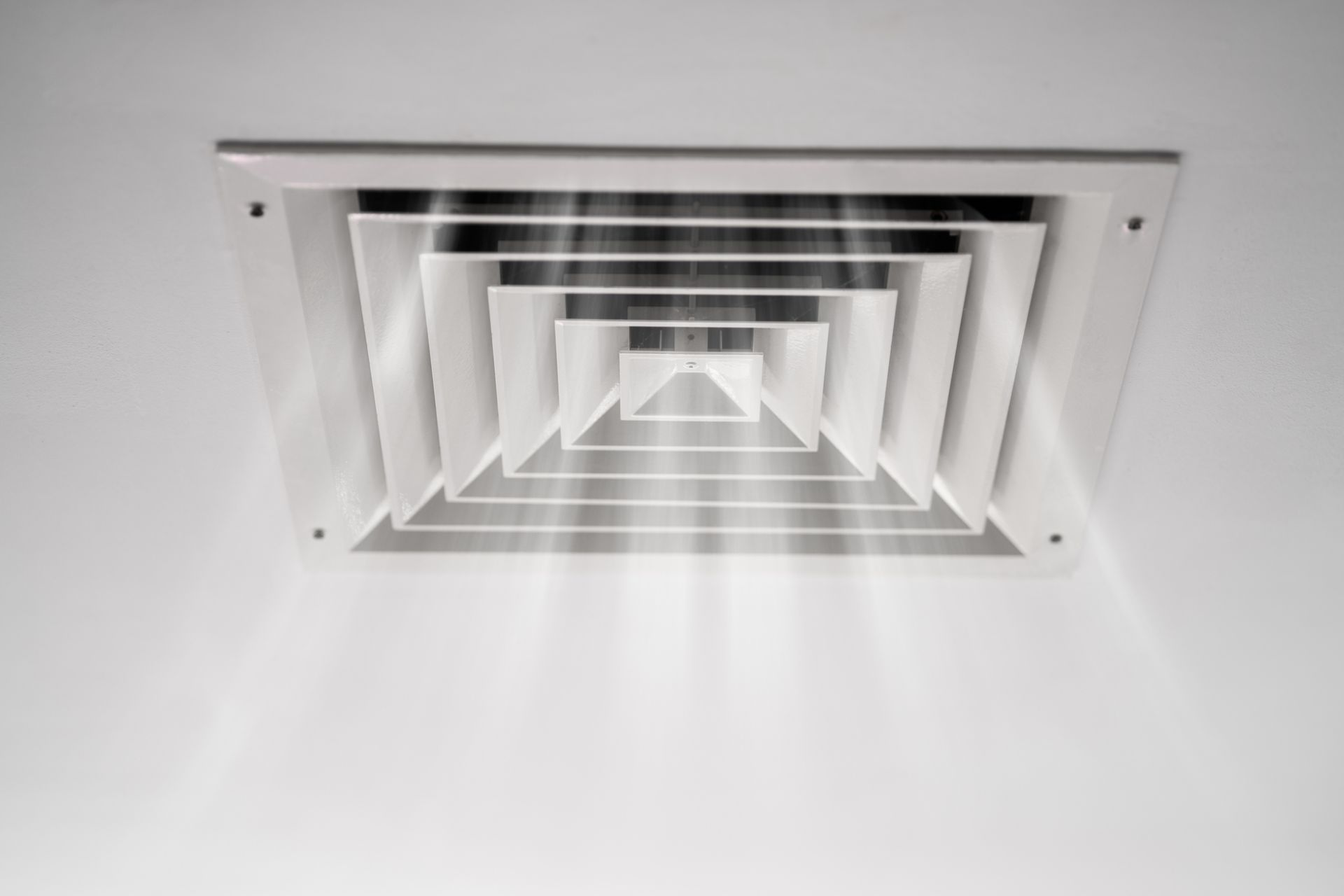 Ceiling air vent with light rays emanating outwards.