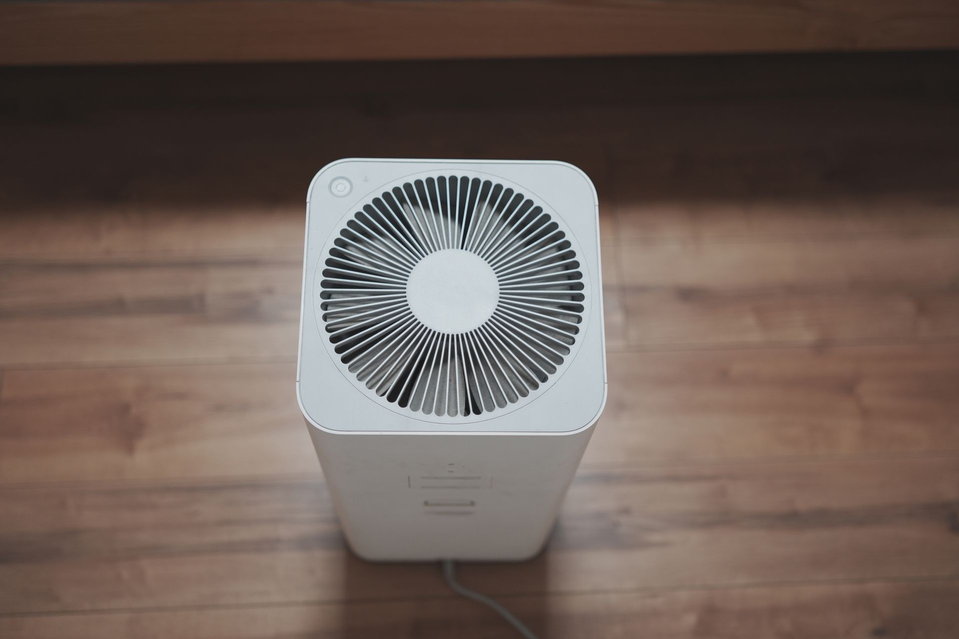 White air purifier on a hardwood floor.