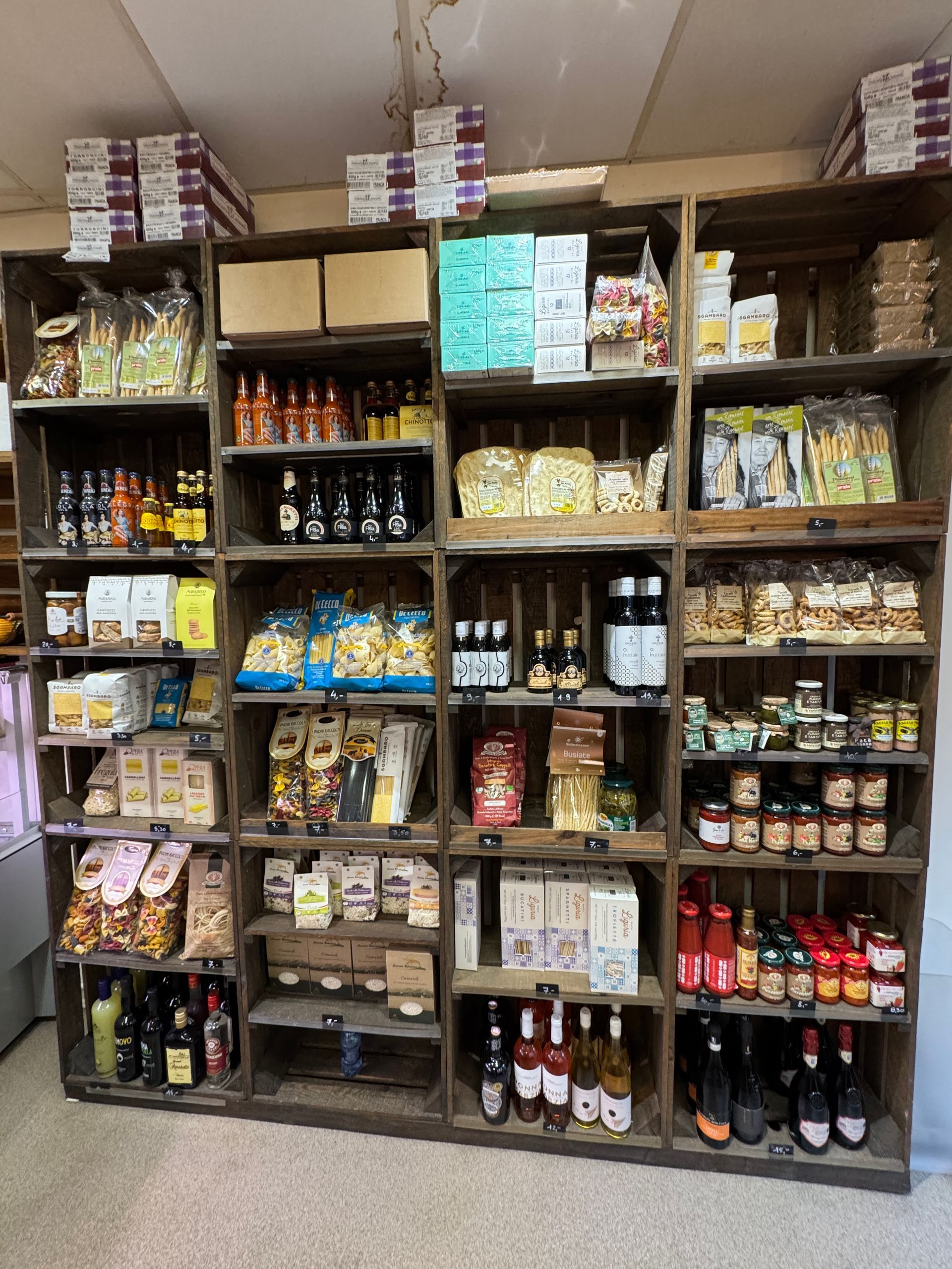 Des étagères en bois remplies de produits alimentaires emballés dans un magasin.