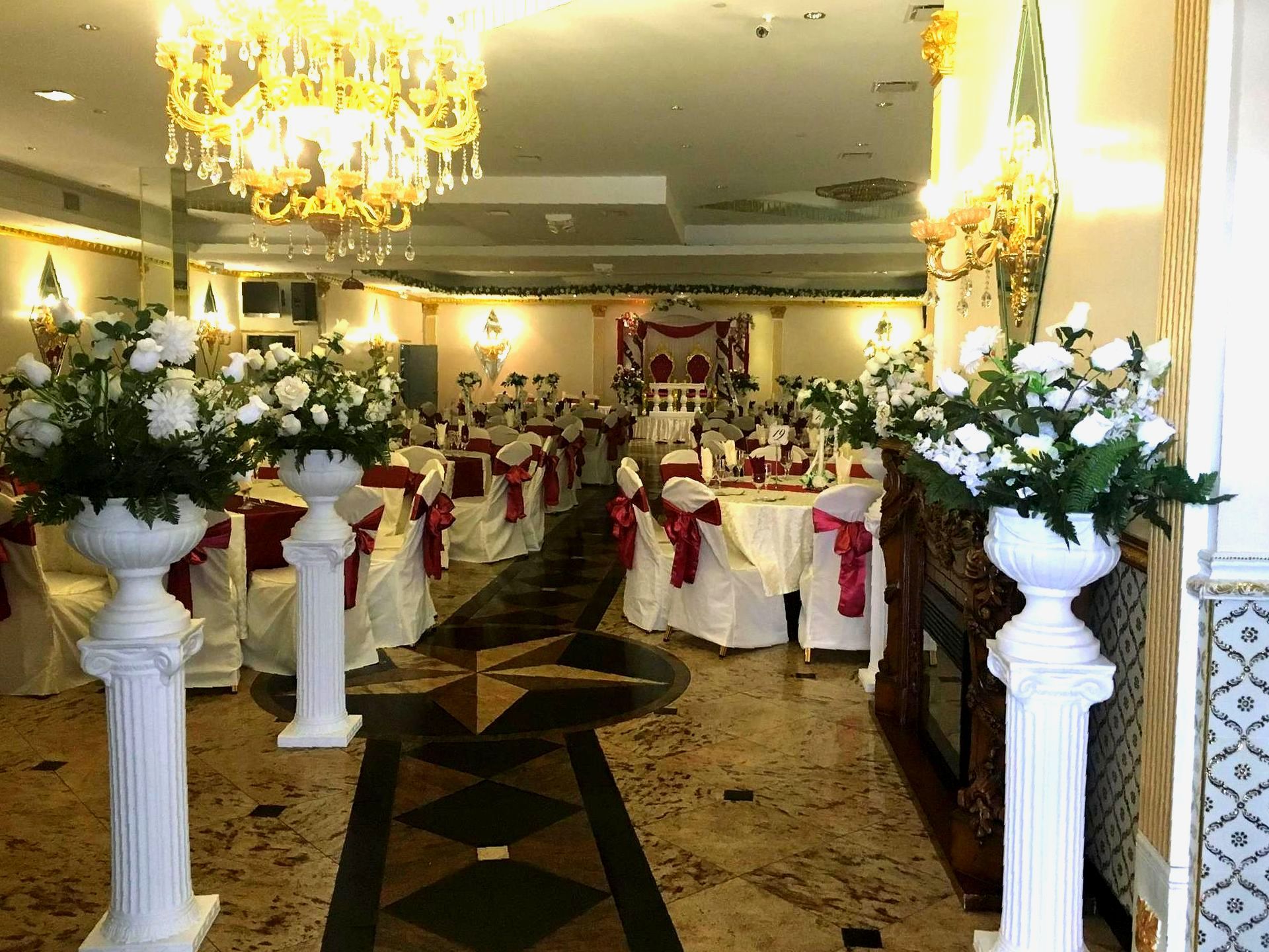 A large room with tables and chairs decorated for a wedding reception.
