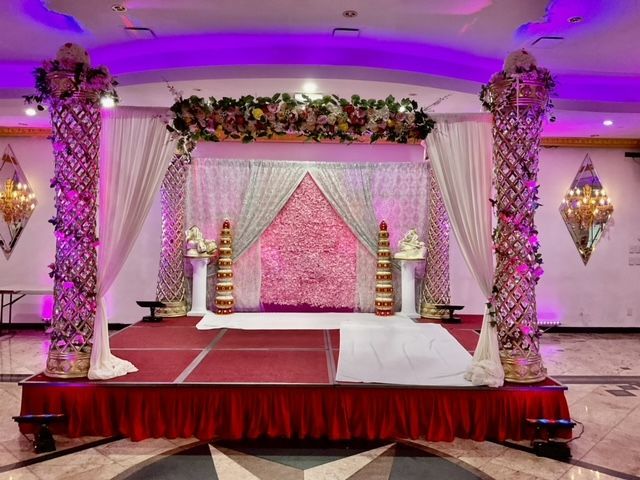 A stage in a room with purple lights and flowers on it.