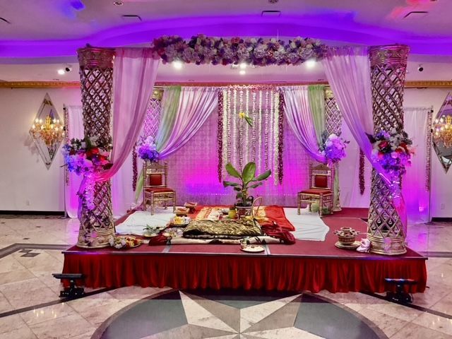There is a stage in the middle of the room decorated for a wedding.