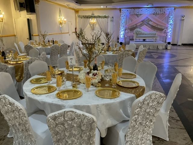 A large room with tables and chairs set up for a wedding reception.