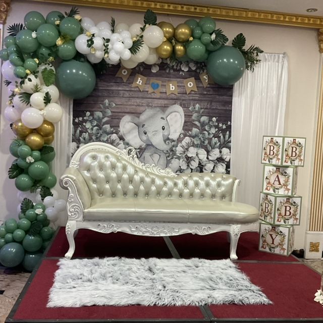 A couch is surrounded by balloons and blocks with the letter b on them