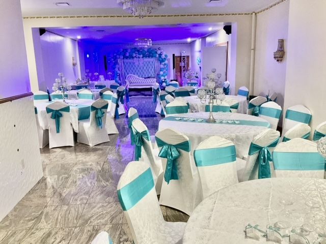 A large room with tables and chairs decorated for a wedding reception.