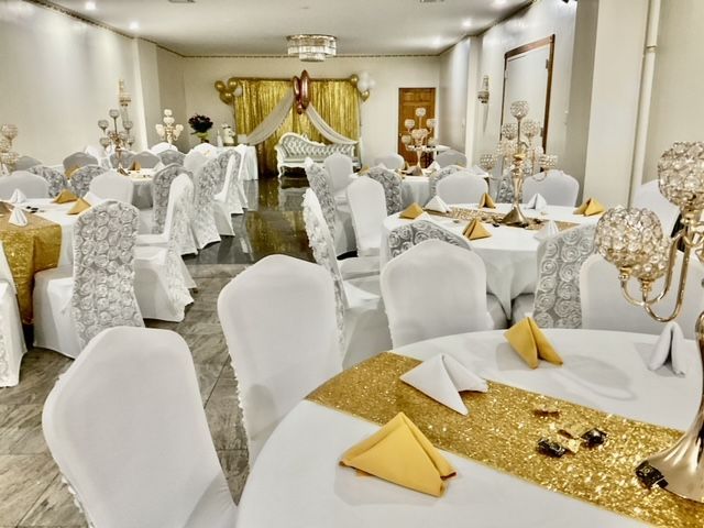A large room with tables and chairs set up for a wedding reception.
