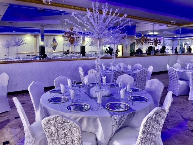 A large room with tables and chairs set up for a wedding reception