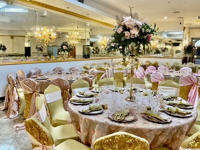 A large room with tables and chairs set up for a wedding reception.