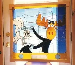 A stained glass window with a moose and a squirrel on it