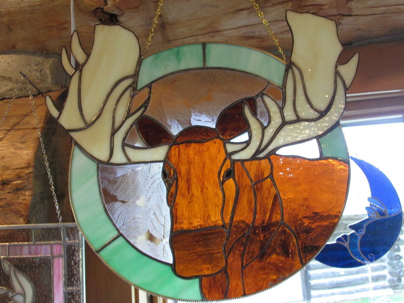 A stained glass picture of a moose with antlers