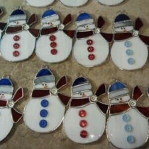 A bunch of stained glass snowmen are sitting on a table.
