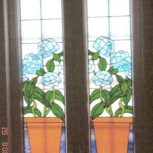 A stained glass window with two potted flowers on it