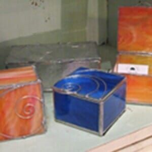 A blue box with a swirl on it sits on a table with other boxes