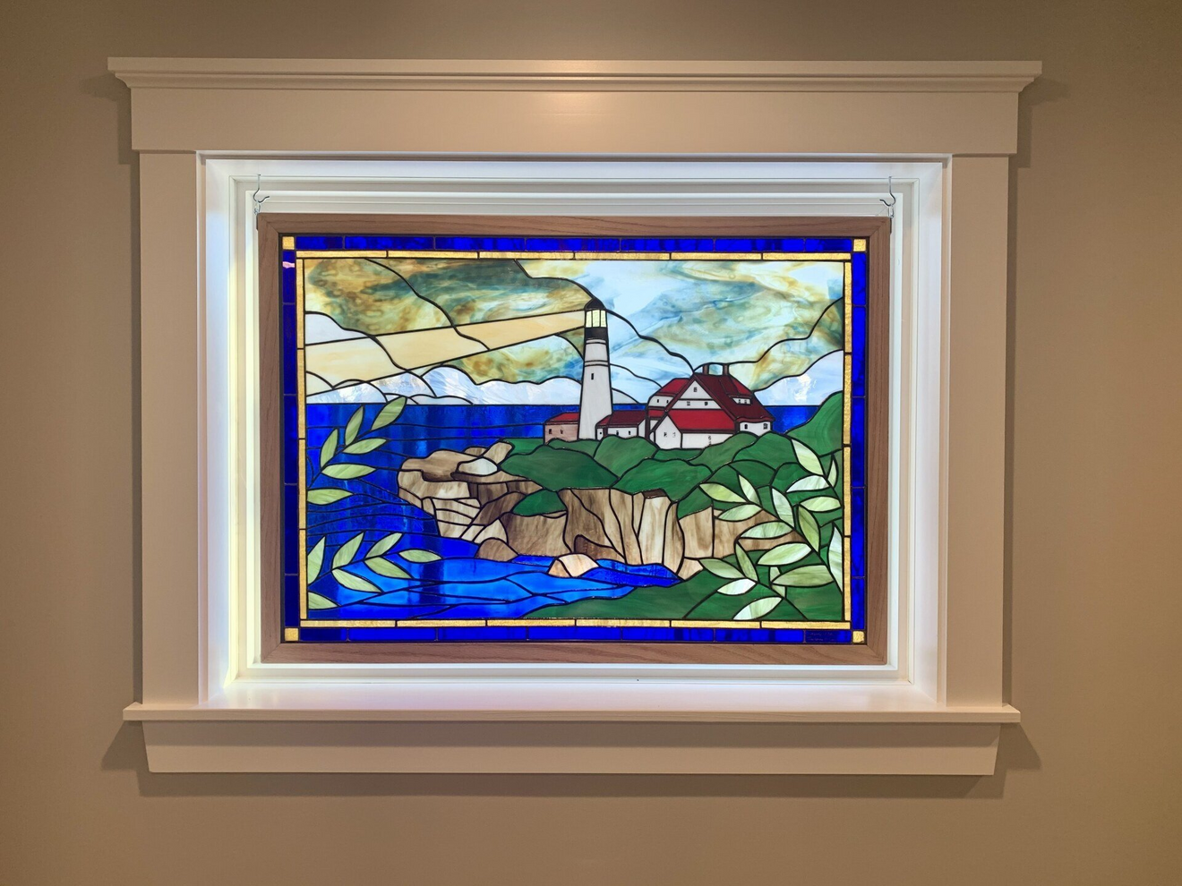 A stained glass window with a lighthouse in the background